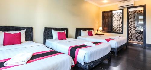 a room with three beds with pink and white sheets at Central Night Hotel in Siem Reap