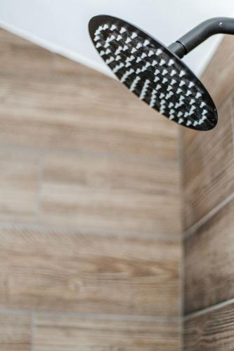 a black toothbrush hanging from a shower head at The Nest in Berkeley Springs