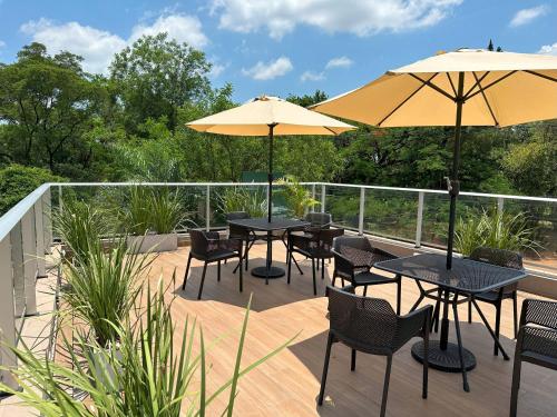 two tables and chairs with umbrellas on a deck at Republica Apartment in Luque