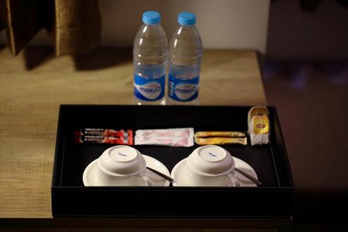 two bottles of water and two tea cups on a table at K.C Residence in Yangon