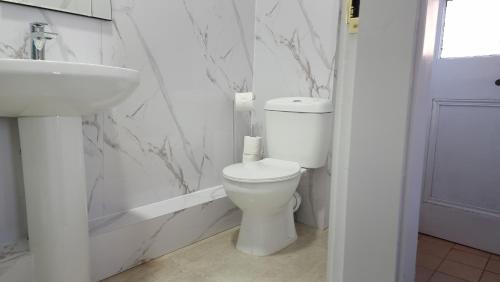 a white bathroom with a toilet and a sink at Ye Olde Hotel in Leuchars