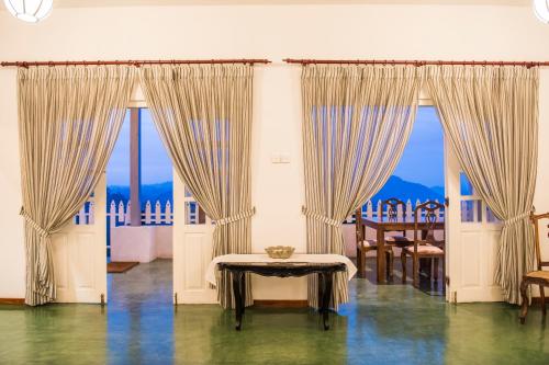 a room with curtains and a table with a view at Villa Perpetua in Bandarawela