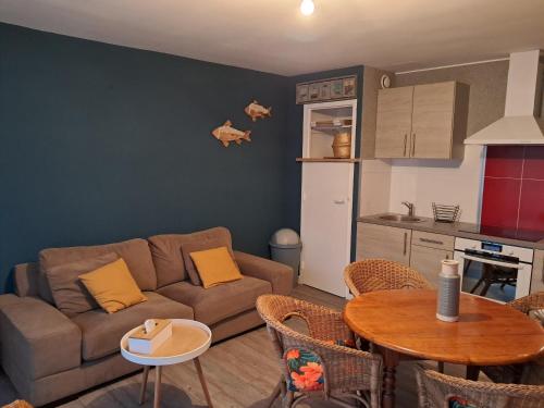 un salon avec un canapé et une table et une cuisine dans l'établissement Appartement 1 chambre face aux dunes, à Merlimont