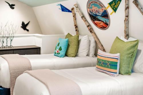 two white beds in a room with birds on the wall at Laid Back Cabin 7 Mn To Glacier, Private Fire Pit in Coram