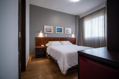 Una cama o camas en una habitación de Piemonte Hotel