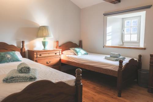 a bedroom with two beds and a window at Gîtes du Château de Meux in Meux