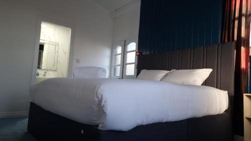 a large white bed in a room with a window at Ye Olde Hotel in Leuchars