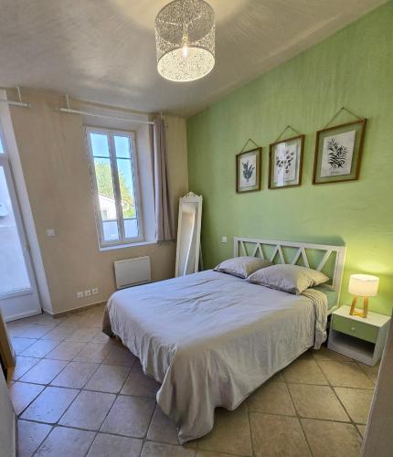 - une chambre avec un lit dans un mur vert dans l'établissement Appartement 55 m2 avec terrasse, clim, WIFI, Netflix, bureau, à Avignon