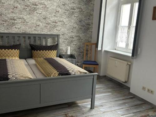 a bedroom with a large bed and a brick wall at Ferienwohnung am Theaterplatz in Meißen