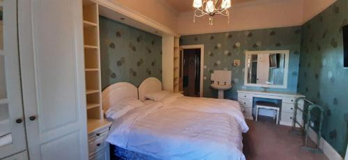 a bedroom with a bed and a desk and a mirror at Marshill Farmhouse in Blackwood
