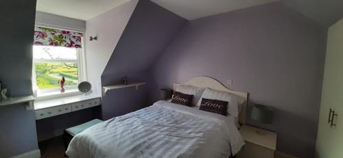 a purple bedroom with a bed and a window at Marshill Farmhouse in Blackwood