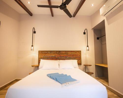a bedroom with a white bed with a blue towel on it at Paradiso Hostel in La Laguna