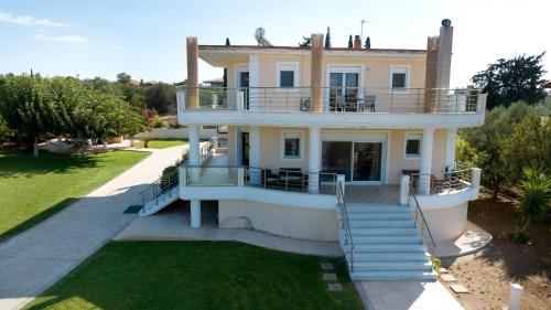 a large house with a staircase in front of it at Villa Eva στην περιοχή Ερέτρια in Eretria