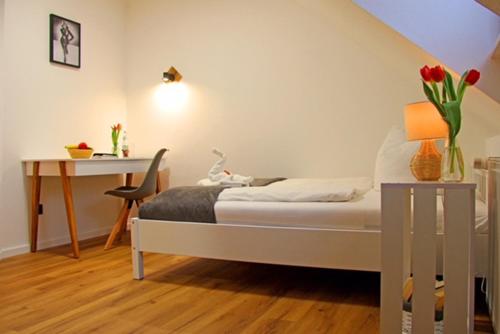a bedroom with a bed and a desk and a table at Gästehaus Lorz in Höchstadt an der Aisch