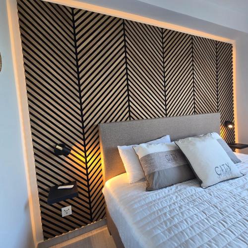 a bedroom with a bed with a black and white striped wall at Marbella city center appartment walking distance beach and plaza de los naranjos in Marbella