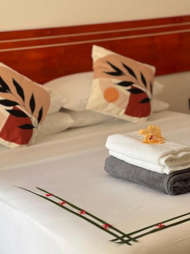 a pile of towels sitting on top of a bed at Thoddoo Cozy Stay in Thoddoo