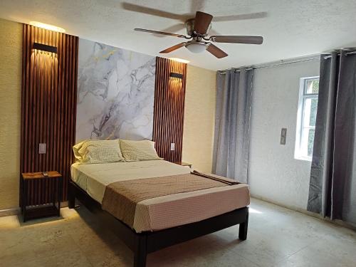 a bedroom with a bed and a ceiling fan at HOTEL SOL in Guadalajara
