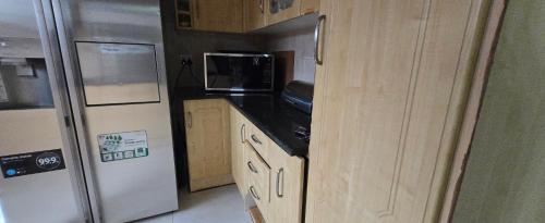 a kitchen with a refrigerator and a microwave at Nature's Retreat in Willowdene