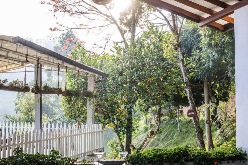 a view from a house with a white fence and trees at Villa Perpetua in Bandarawela
