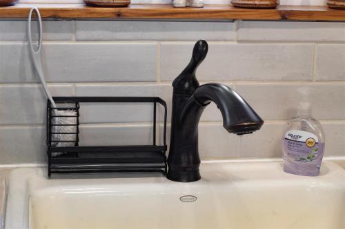 a sink with a black faucet and a soap bottle at Gnomerson’s Hideaway in Packwood