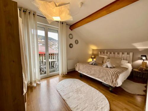 une chambre avec deux lits et une grande fenêtre dans l'établissement Le Cocon de Sophie, joli appartement avec terrasse, à Gérardmer