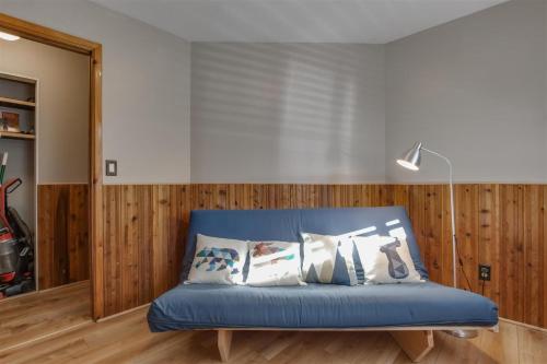 a blue couch in a room with wooden walls at Gnomerson’s Hideaway in Packwood