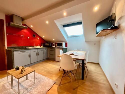 une cuisine et une salle à manger avec une table et des chaises dans l'établissement Le Cocon de Sophie, joli appartement avec terrasse, à Gérardmer