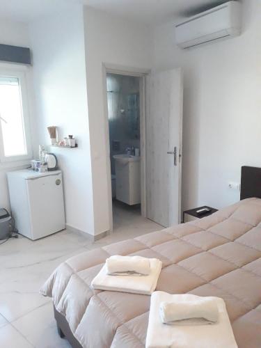 a white room with two beds and a bathroom at Spiridoula's Apartments Corfu in Perama