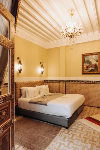 a bedroom with a bed and a chandelier at Riad Ksar Al Amal & Spa in Marrakech