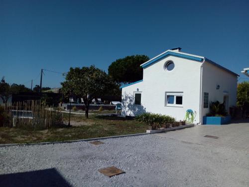 a small white house with a driveway in front of it at A pequena casa azul in Senhora das Febres
