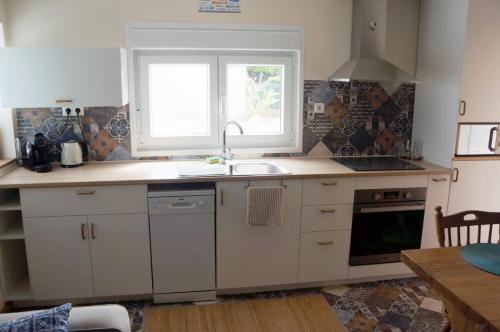 a kitchen with a sink and a window at A pequena casa azul in Febres