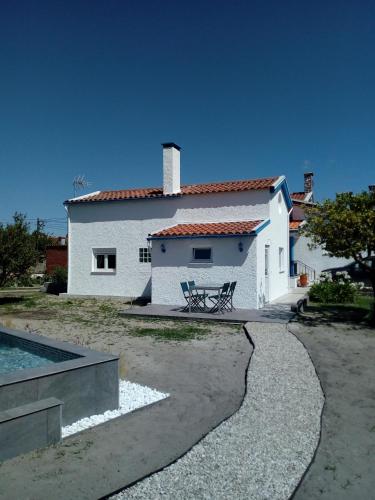 a white house with a swimming pool in front of it at A pequena casa azul in Senhora das Febres