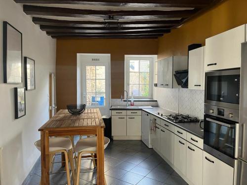 a kitchen with a wooden table and a table and chairs at Belle maison de ville in Alençon