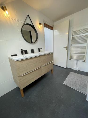 une salle de bain avec un lavabo et un miroir au mur dans l'établissement Belle maison de ville, à Aleçon