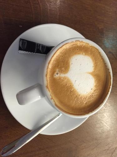 a cup of coffee on a plate with a spoon at Amazing View Port Golfe-Juan and Garage in Golfe-Juan