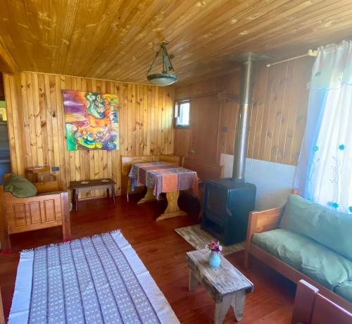 a living room with a couch and a stove at Cabaña en Contao Carretera Austral Hualaihué in Contao