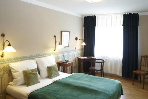 a bedroom with a bed and a desk and a window at Hotel Sonnenhof in Hanau am Main
