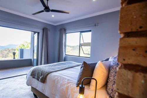 a bedroom with a bed and a large window at Sink Huis at Benlize in Pelindaba