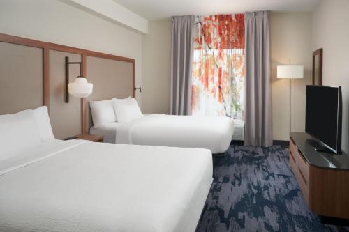 a hotel room with two beds and a flat screen tv at Fairfield Inn & Suites by Marriott Orlando International Drive/Convention Center in Orlando