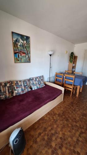 une chambre avec un grand lit et une table et des chaises dans l'établissement Le Petit Bouleau, à Saint-Pardoux-la-Rivière