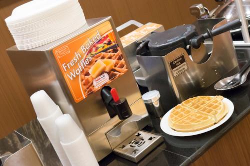 a counter with a waffle maker and a plate of waffles at Fairfield Inn & Suites by Marriott Orlando International Drive/Convention Center in Orlando
