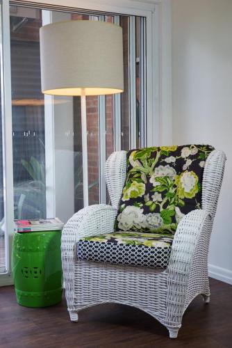 a wicker chair with a pillow sitting next to a lamp at Edward Lodge New Fam in Brisbane