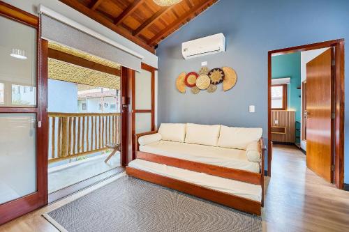 ein Wohnzimmer mit Couch und Balkon in der Unterkunft Bahasa Itagua in Ubatuba