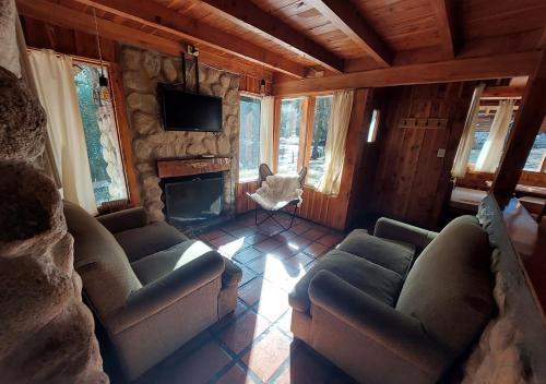 a living room with two couches and a fireplace at Ruma Andina by DOT Cabana in Villa La Angostura