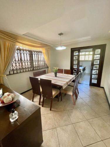 a dining room with a table and chairs at Casa Grande 3 quartos, perto parque Barigui in Curitiba