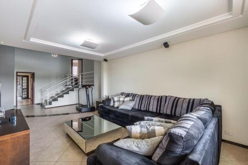 a living room with a couch and a table at Casa Grande 3 quartos, perto parque Barigui in Curitiba
