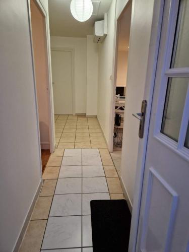 an empty hallway with a door and a tile floor at Bien proche de Aeroport St Exupéry Village de Marques et Lyon in Diémoz