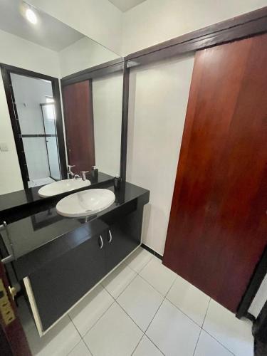 a bathroom with two sinks and a wooden door at Casa Grande 3 quartos, perto parque Barigui in Curitiba