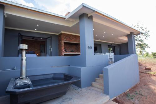 a house with a bathtub on the side of it at Sink Huis at Benlize in Pelindaba