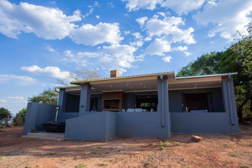 a house with a blue wall at Sink Huis at Benlize in Pelindaba